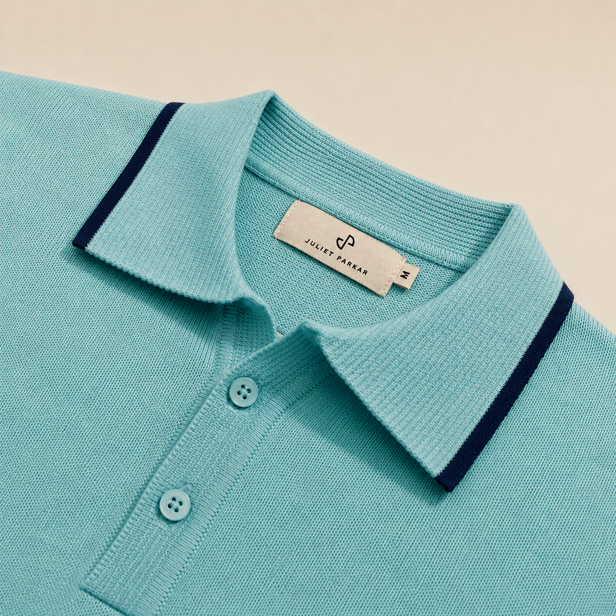 Close-up of the collar and button placket on the Men's Aqua Blue Classic Polo in 100% cotton piqué by Juliet Parkar