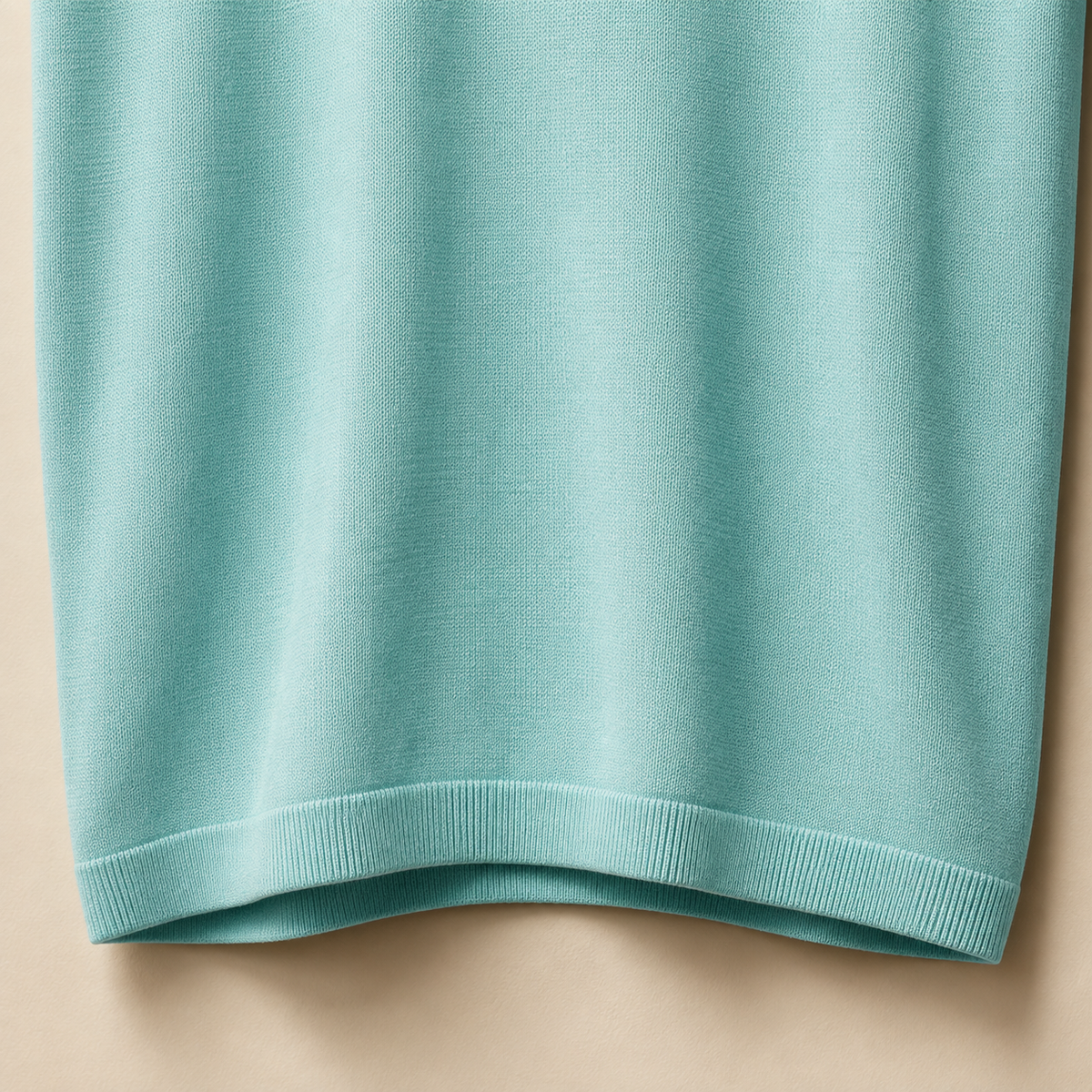 Close-up of the 100% cotton piqué fabric and bottom hem stitching on the Men's Aqua Blue Classic Polo by Juliet Parkar