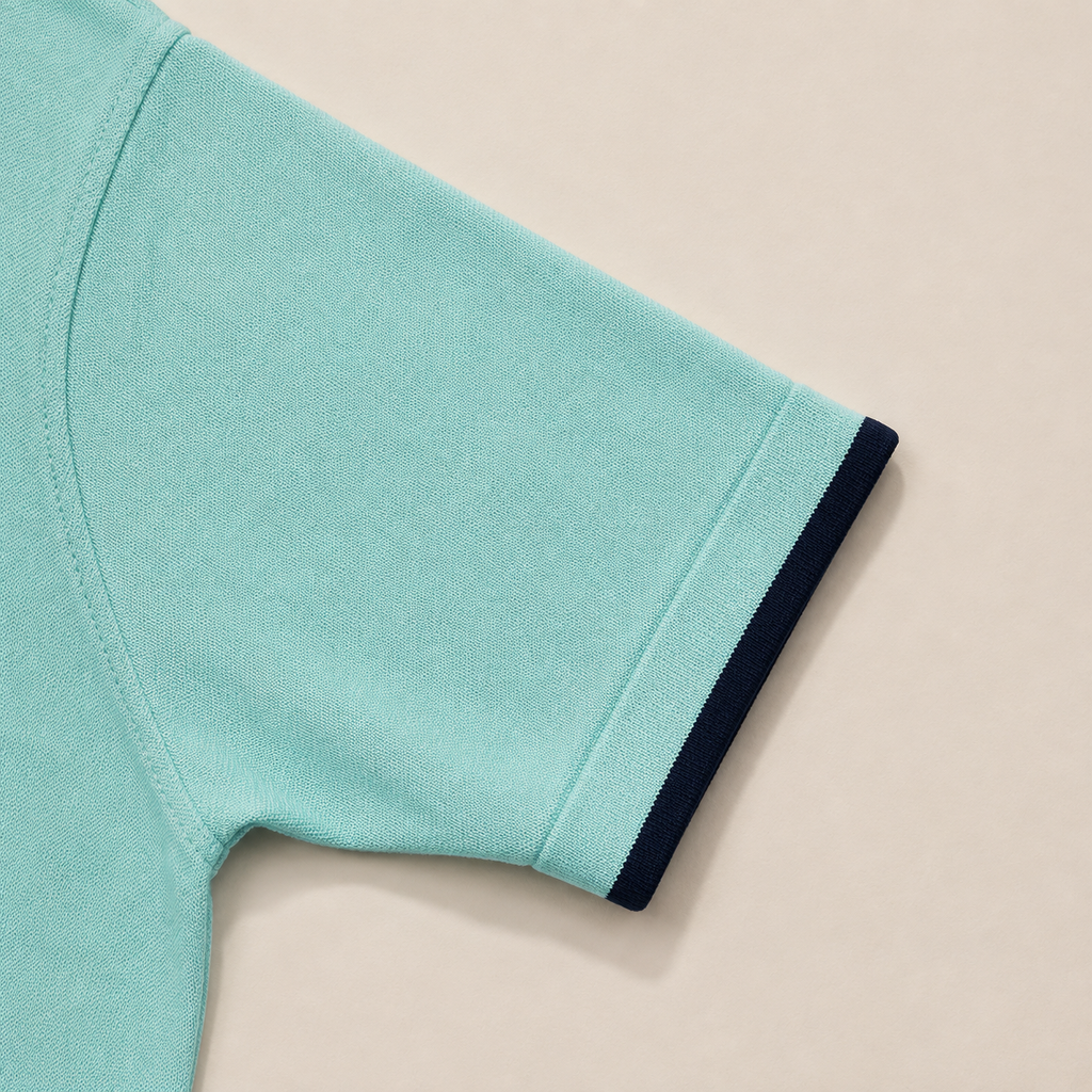 Close-up of the short sleeve with ribbed cuff on the Men's Aqua Blue Classic Polo in 100% cotton piqué by Juliet Parkar