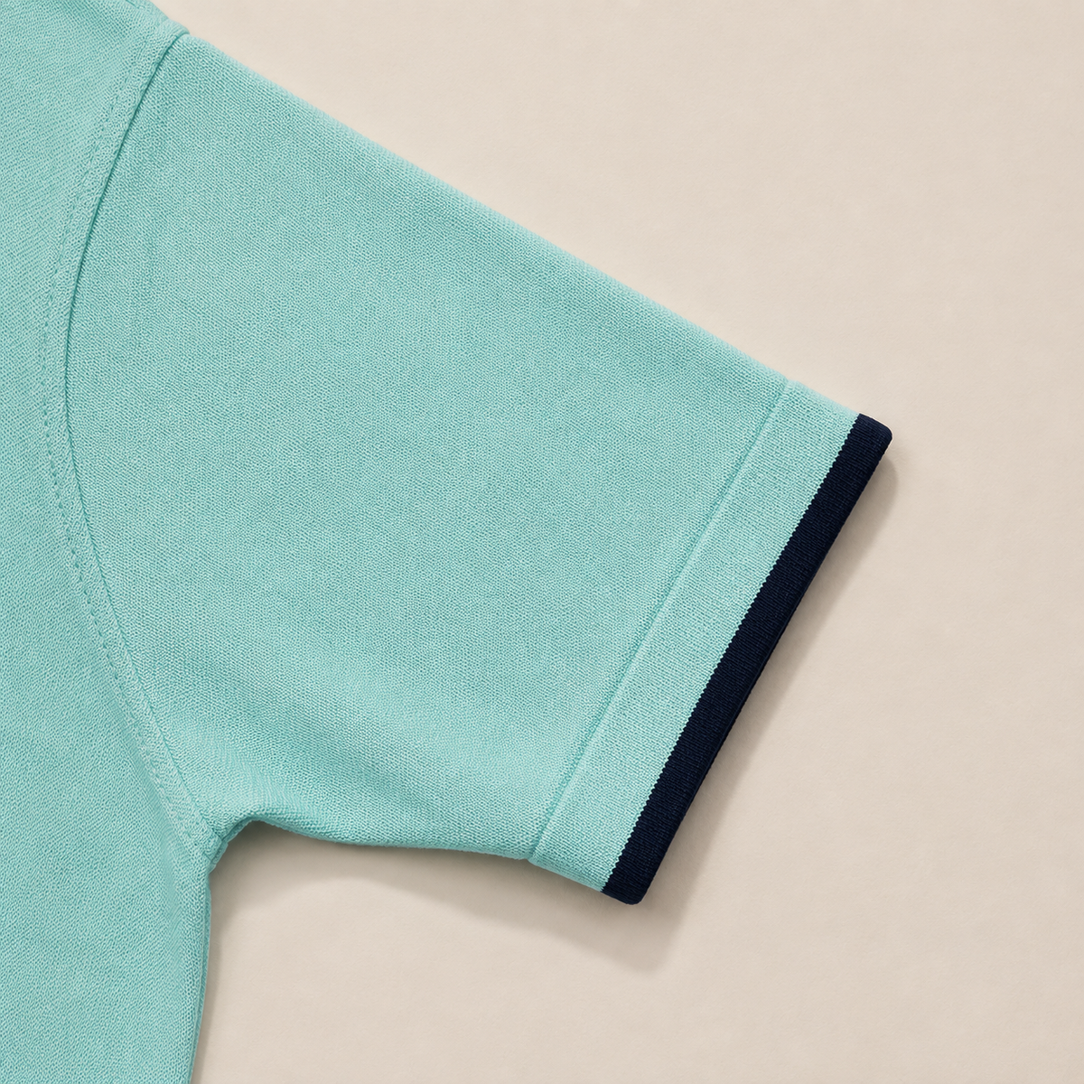Close-up of the short sleeve with ribbed cuff on the Men's Aqua Blue Classic Polo in 100% cotton piqué by Juliet Parkar