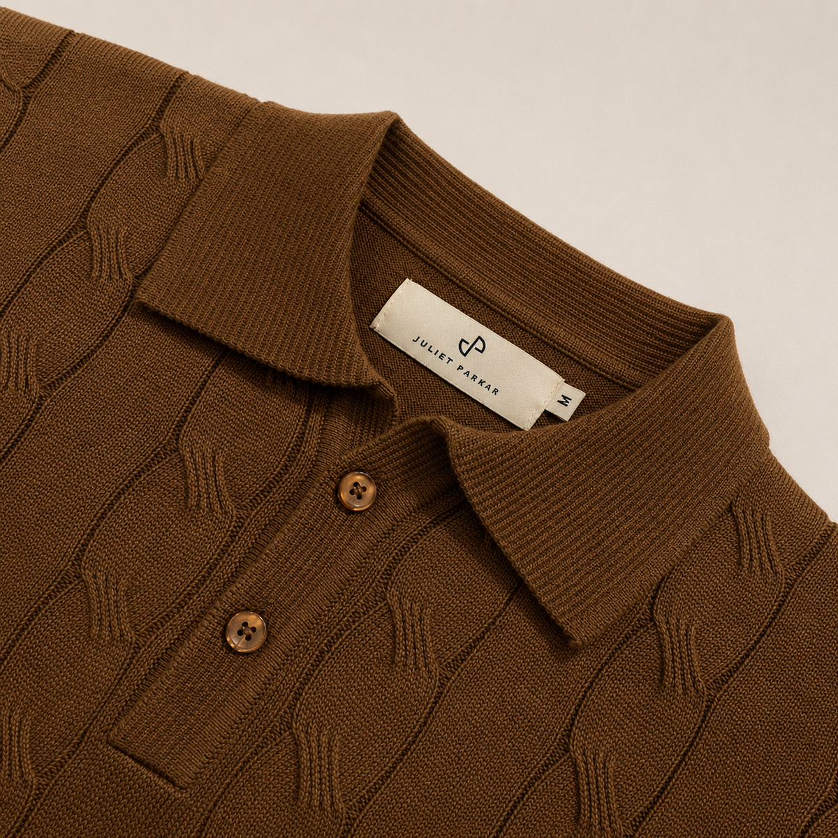 Close-up of the collar and button placket on the Men's Brown Cable Knit Polo in 100% cotton by Juliet Parkar