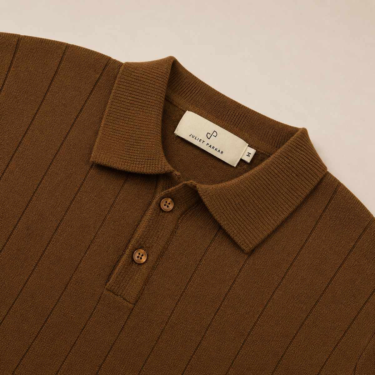 Close-up of the collar and button placket on the Men's Brown Rib Knit Polo in 100% cotton by Juliet Parkar