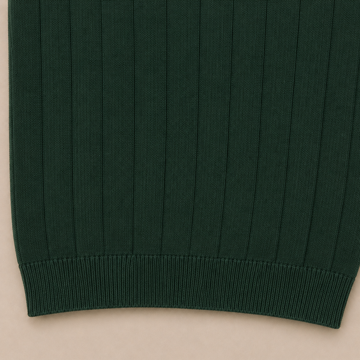 Close-up of the 100% cotton fabric and bottom hem stitching on the Men's Forest Green Rib Knit Polo by Juliet Parkar