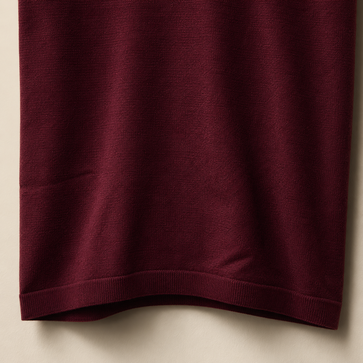 Close-up of the 100% cotton piqué fabric and bottom hem stitching on the Men's Maroon Classic Polo by Juliet Parkar