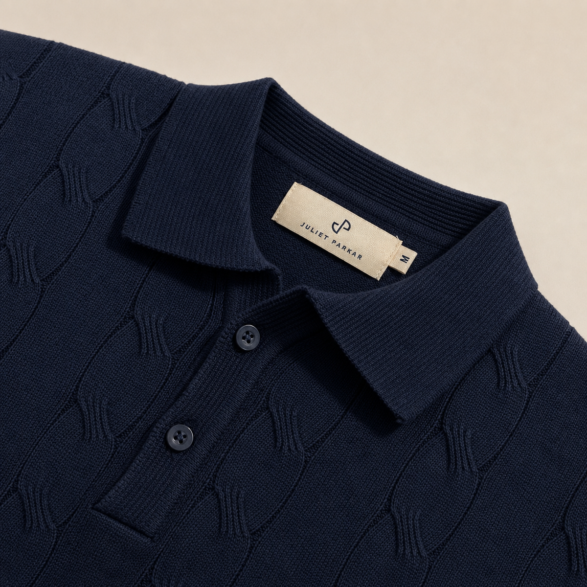 Close-up of the collar and button placket on the Men's Navy Blue Cable Knit Polo in 100% cotton by Juliet Parkar