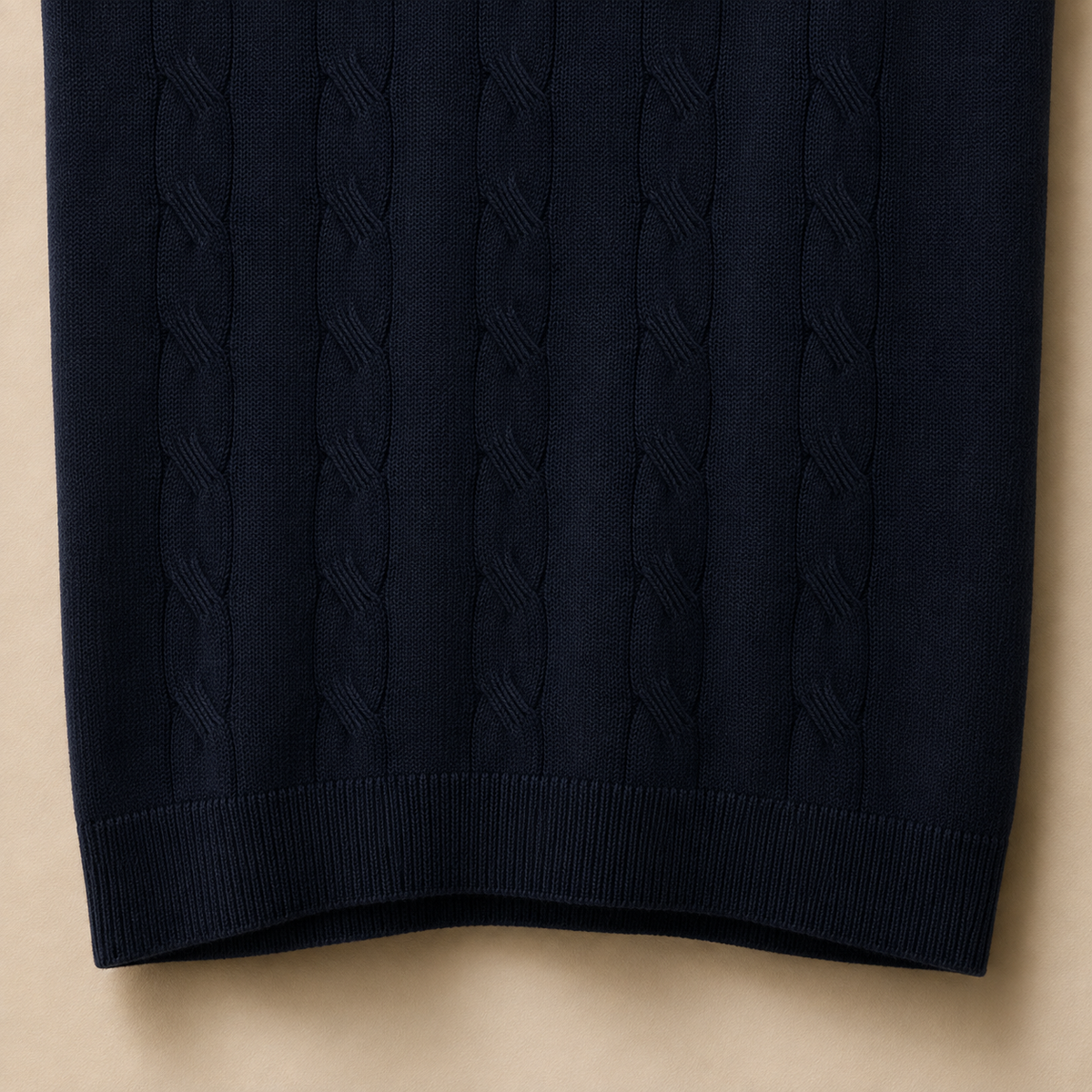 Close-up of the 100% cotton fabric and bottom hem stitching on the Men's Navy Blue Cable Knit Polo by Juliet Parkar