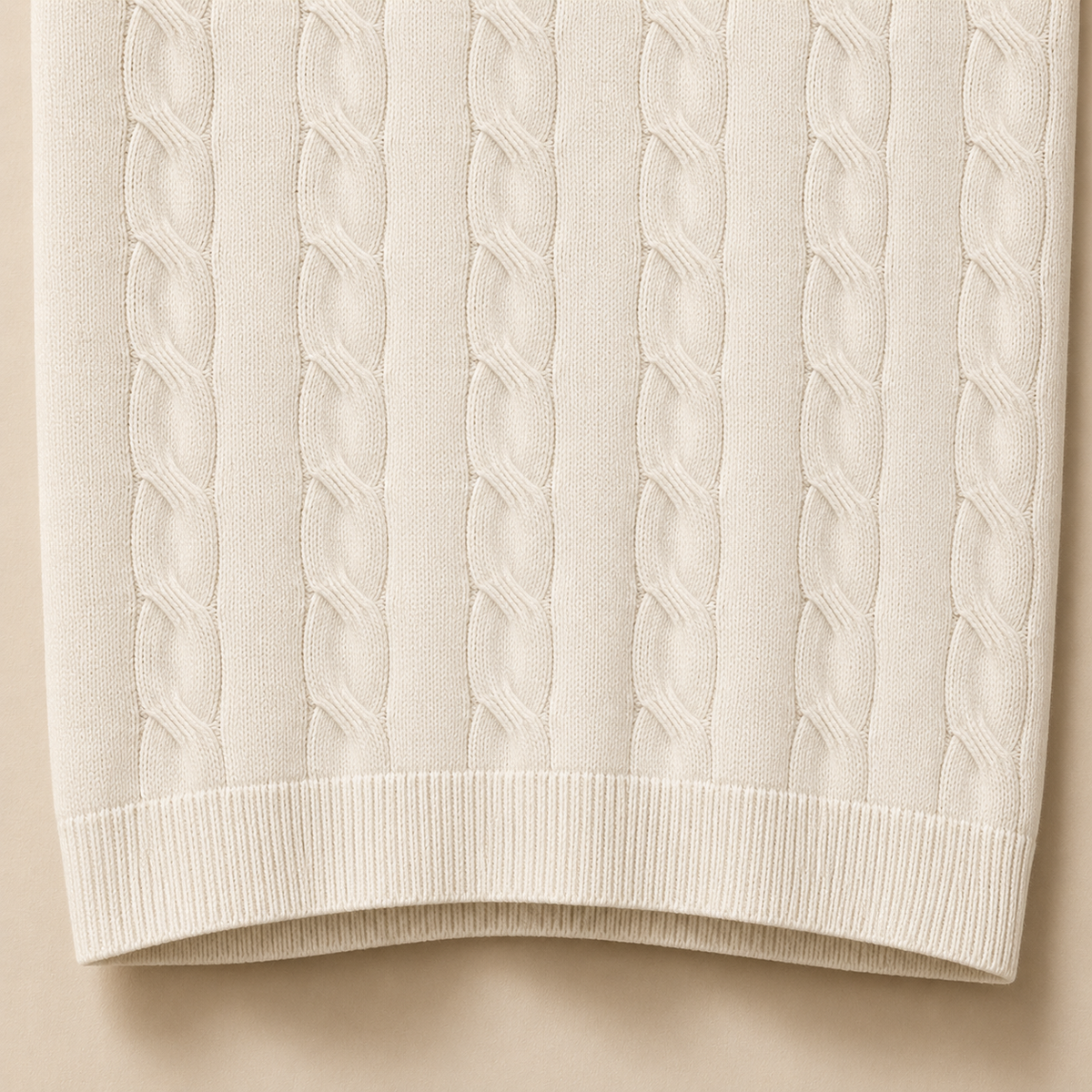 Close-up of the 100% cotton fabric and bottom hem stitching on the Men's Pearl White Cable Knit Polo by Juliet Parkar