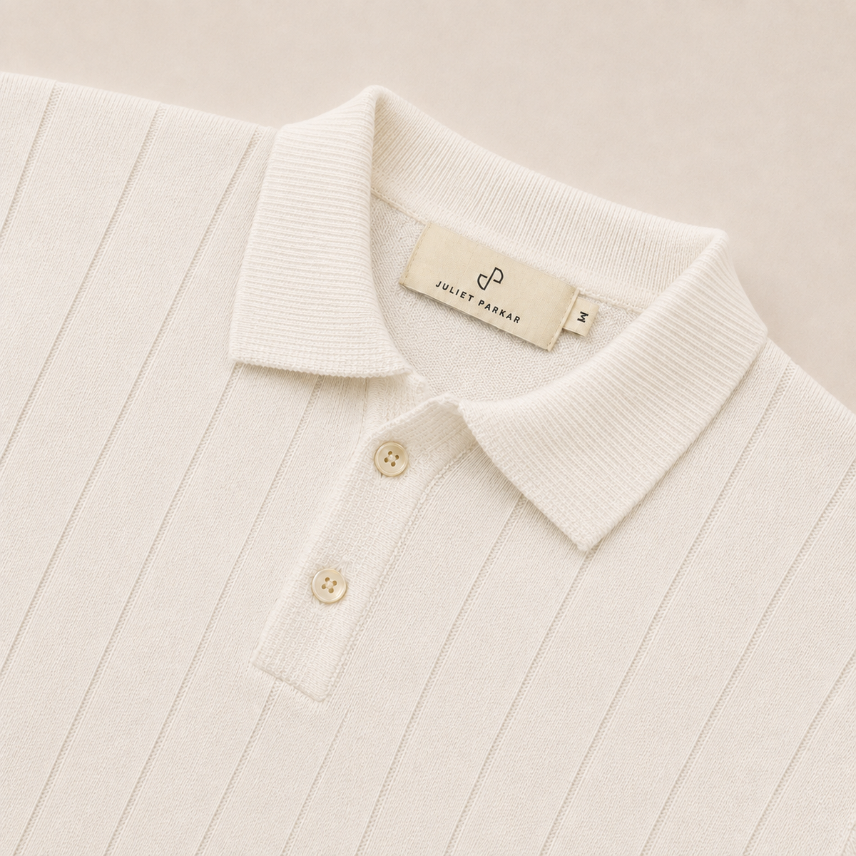 Close-up of the collar and button placket on the Men's Pearl White Rib Knit Polo in 100% cotton by Juliet Parkar